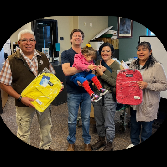 Dustin and Felicia Boyd with the Lt. Governor of Zia Pueblo and Martha from Zia Education Services, holding backpacks donated by Lieber's Luggage to the Zia Pueblo education system